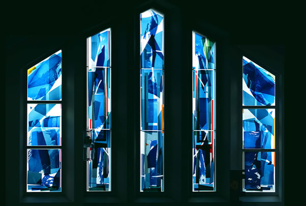 Kath. Kirche Heilige Dreifaltigkeit, Ostseebad Kühlungsborn. Gestaltung Chorfenster. Mehrschichtige Glascollage, Zuschnitt aus Echt-Antiküberfanggläsern, mehrfach geätzt, flächig auf Sicherheitsglas laminiert und als zusätzliche innere Scheibe montiert.