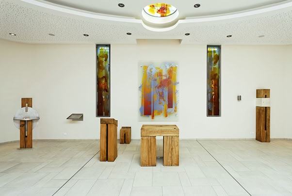 Niels-Stensen-Kliniken, Christliches Klinikum, Melle. Kapelle. Altarbild: Mehrschichtige Malerei und Siebdruck mit Glasschmelzfarben auf Floatglas, mit Abstand vor der Wand montiert. Fenstergestaltung: Mehrschichtige Glascollage, Zuschnitt aus Opal-und Echt-Antiküberfanggläsern, mehrfach geätzt, partiell mit Glasschmelzfarbe bemalt, flächig auf Sicherheitsglas laminiert und im Scheibenzwischenraum der Isolierverglasung montiert. Prinzipalien: Eichenholz massiv, mit der Kettensäge aus dem vollen Stamm geschnitten, teilweise in Kombination mit glasperlengestrahltem Edelstahl. Tabernakel blattvergoldet (Weissgold).